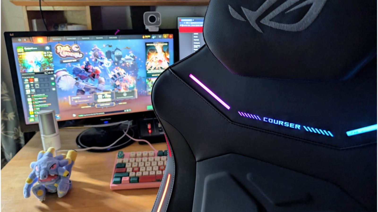 Headrest and back panel of Asus ROG Courser gaming chair in front of a desk setup