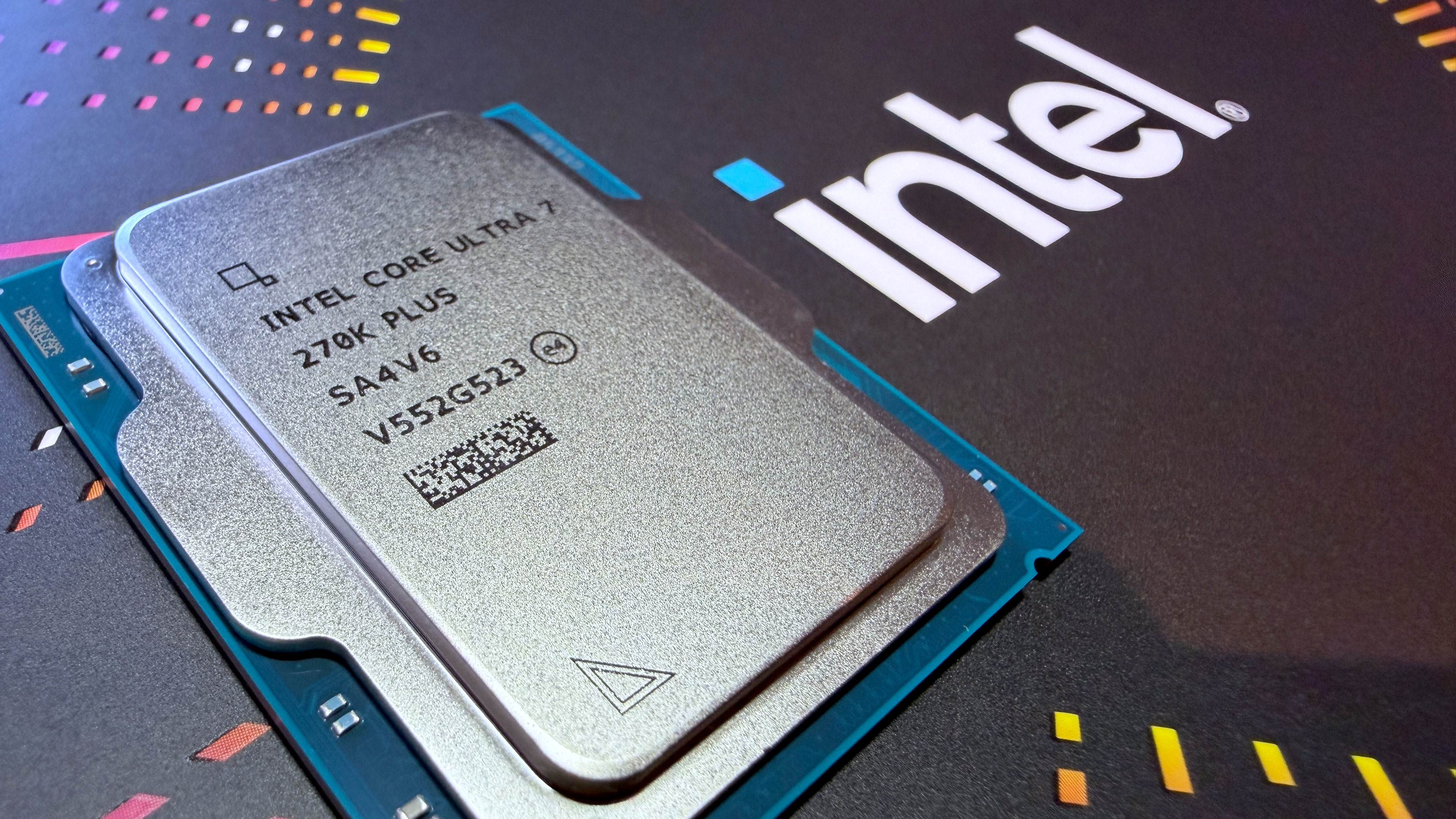 A photo of an Intel Core Ultra 7 270K Plus processor, resting against a colorful, Intel-branded box